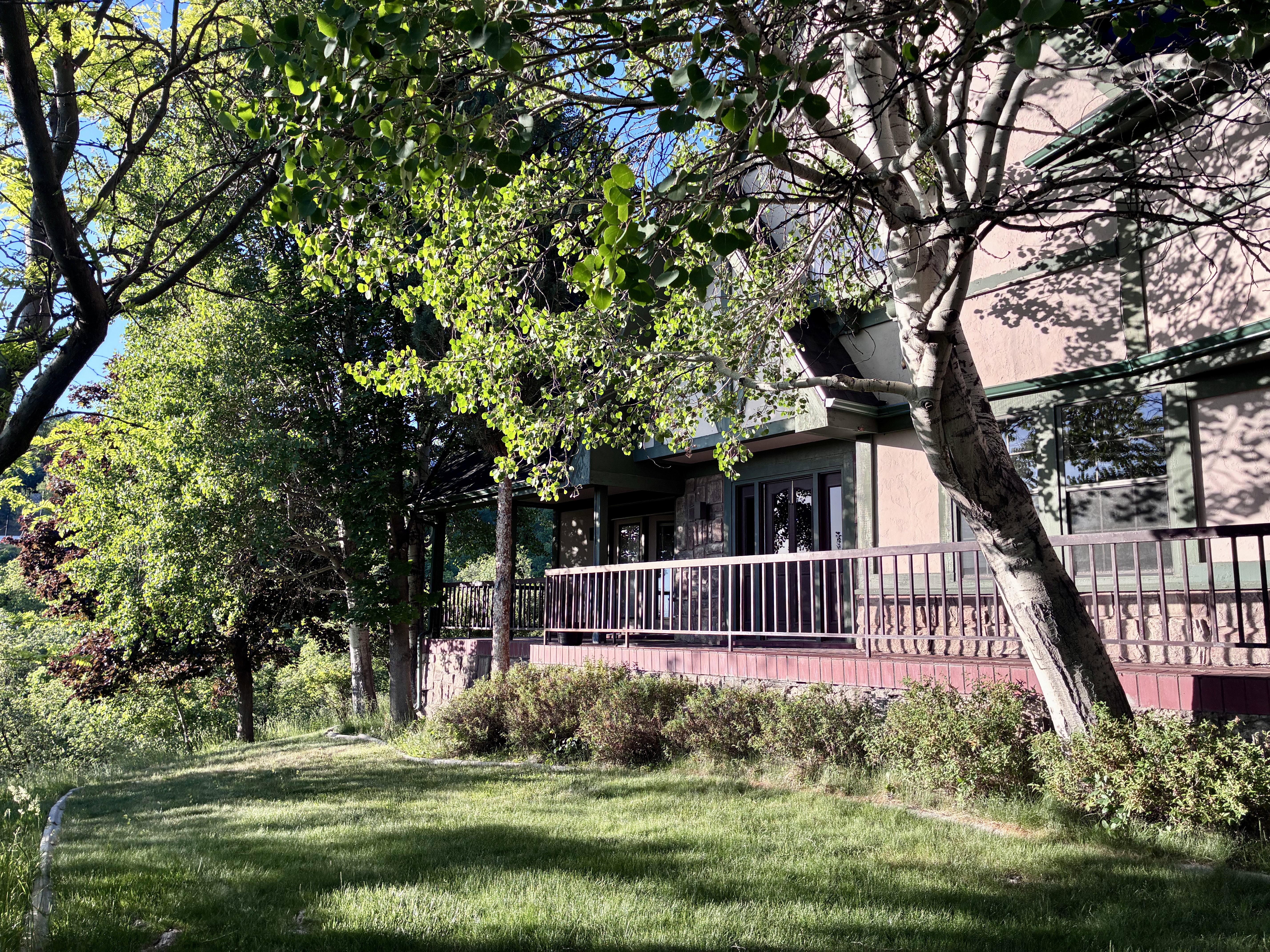 Expansive outdoor deck featuring a wooden railing system and a stone base