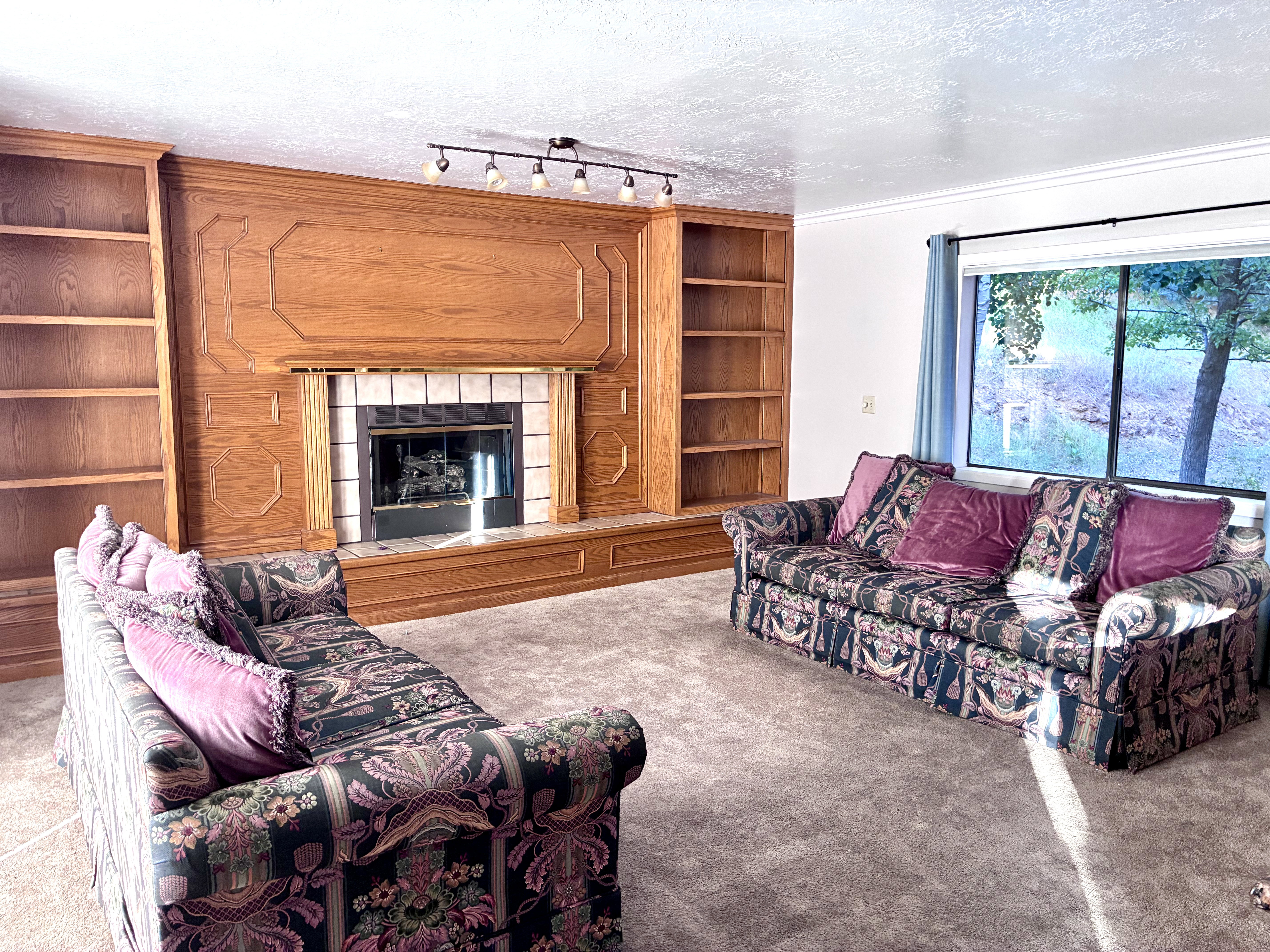 Built-in wood cabinetry with integrated shelving frames a tile surround fireplace