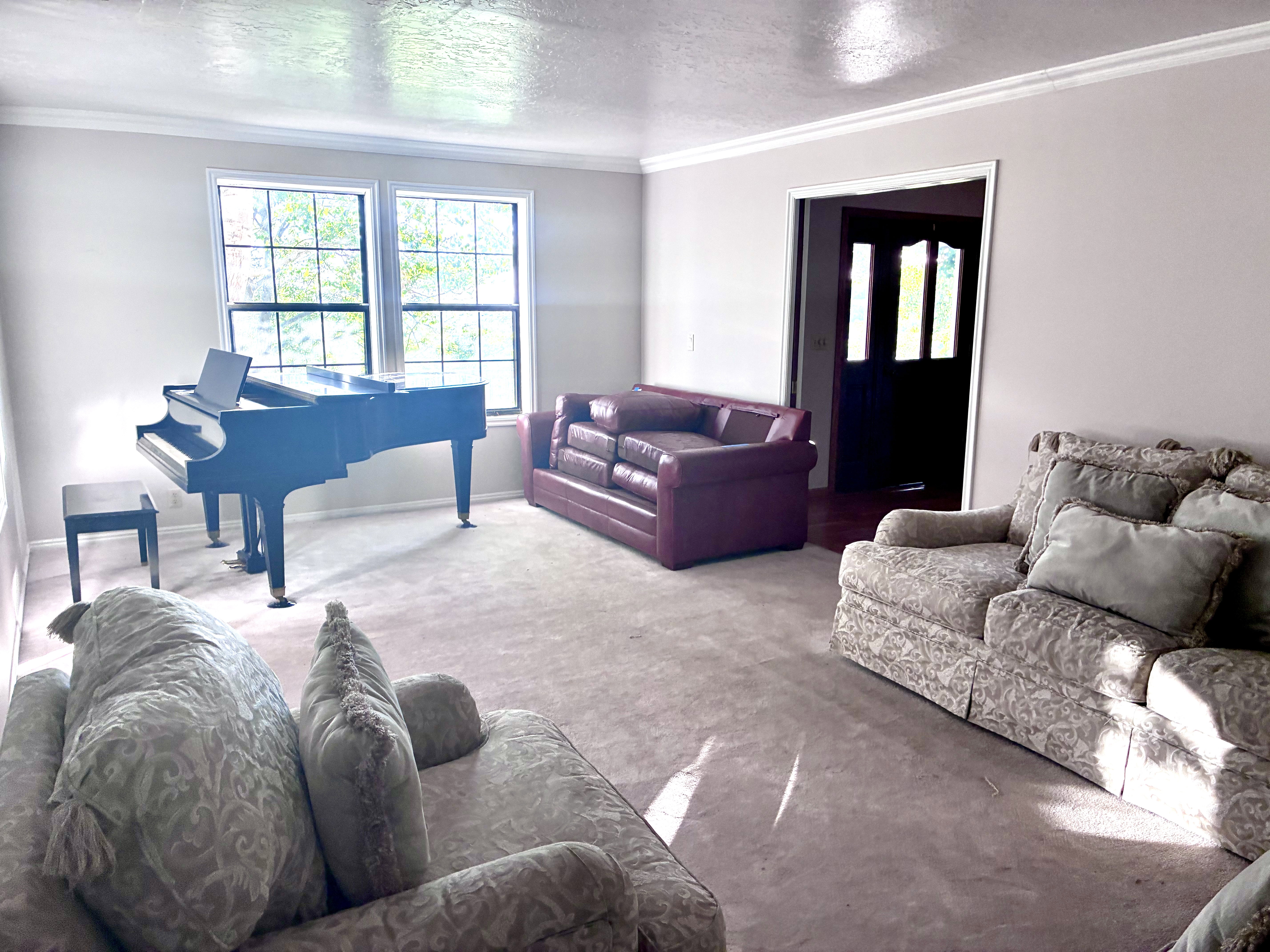 Living area featuring a textured ceiling, crown molding, and neutral wall tones