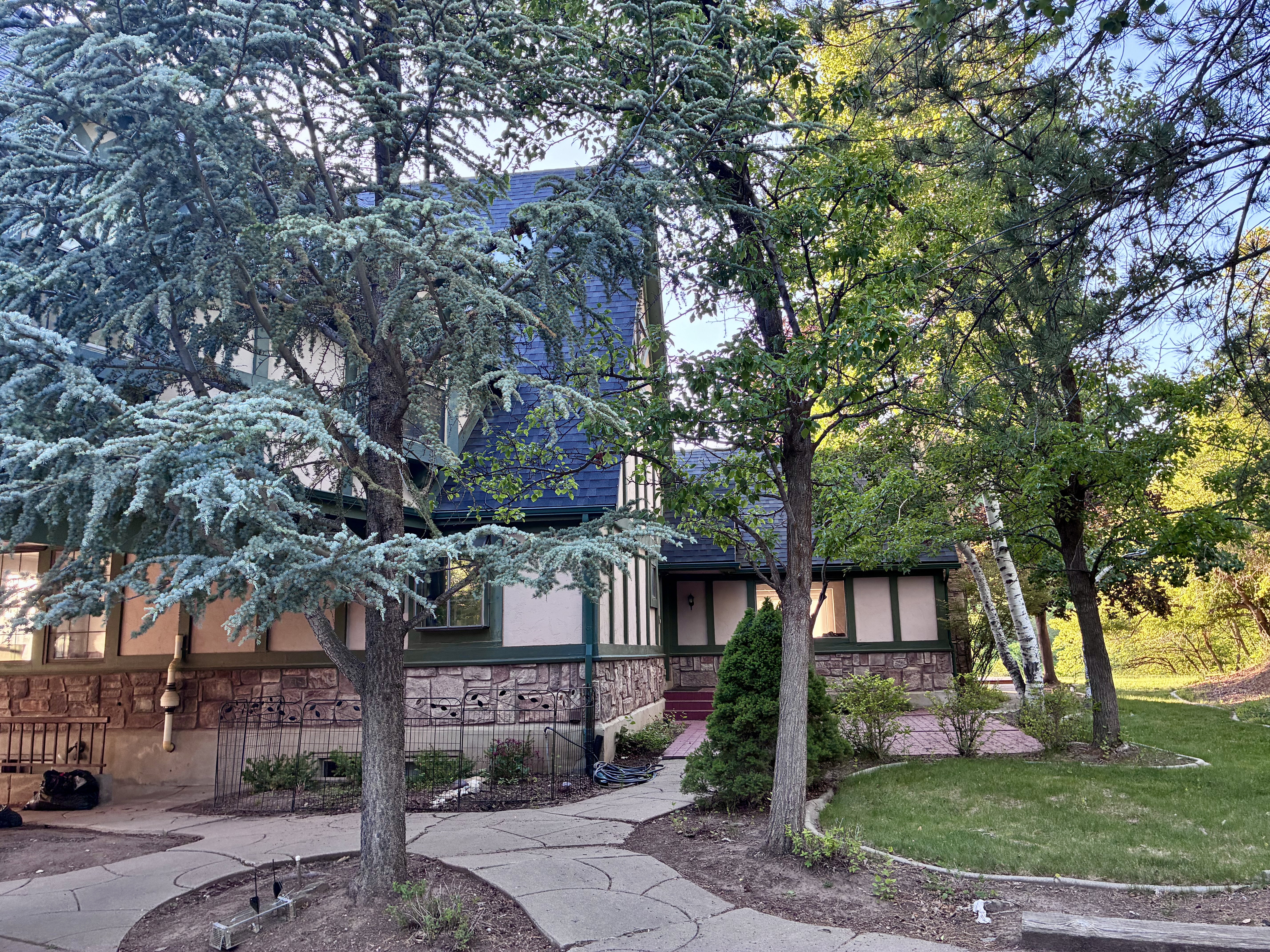 Multi-story exterior with a stone and stucco facade, complemented by a dark blue roof