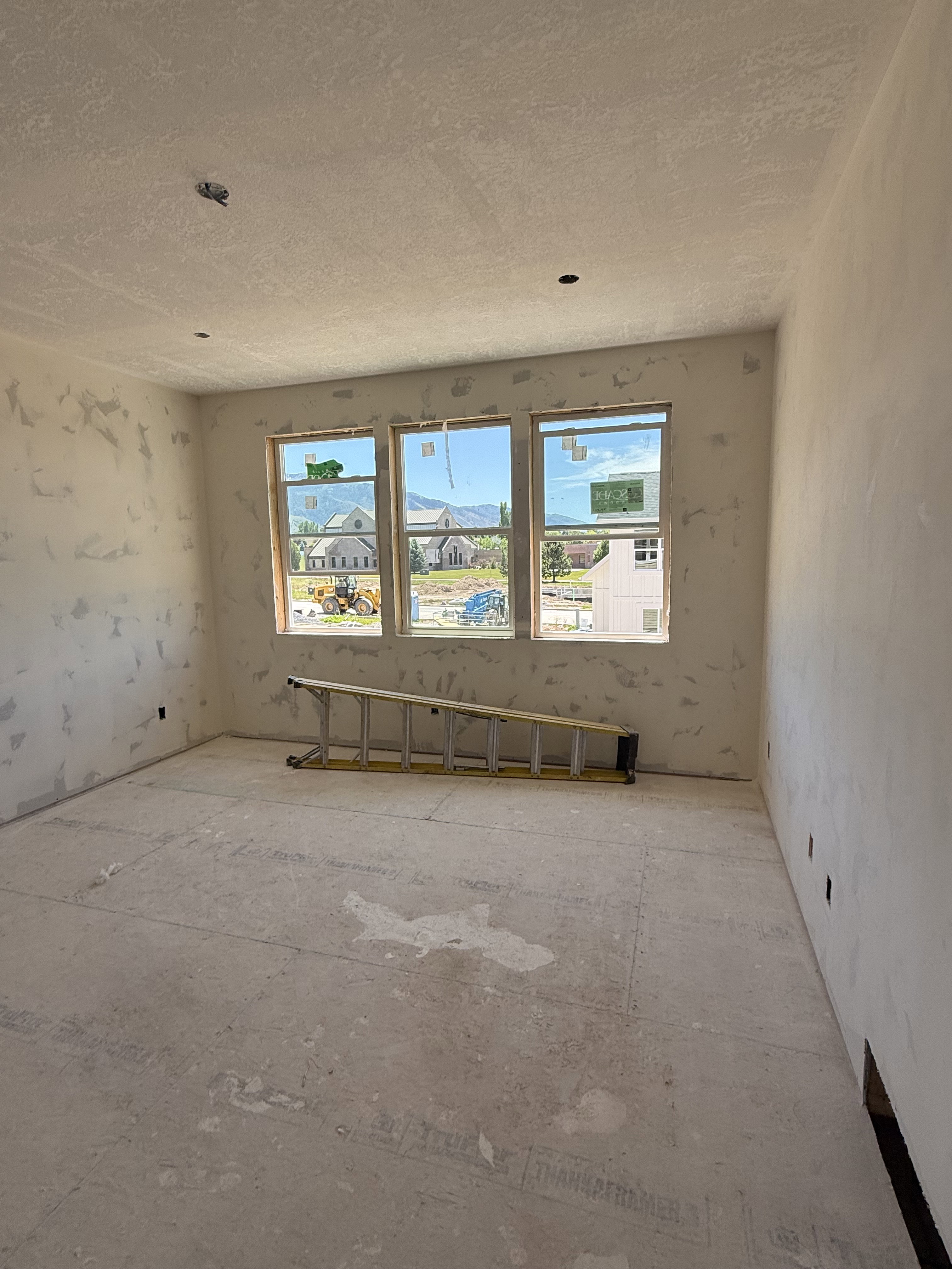 Room with three large windows, a flat ceiling, and a concrete subfloor