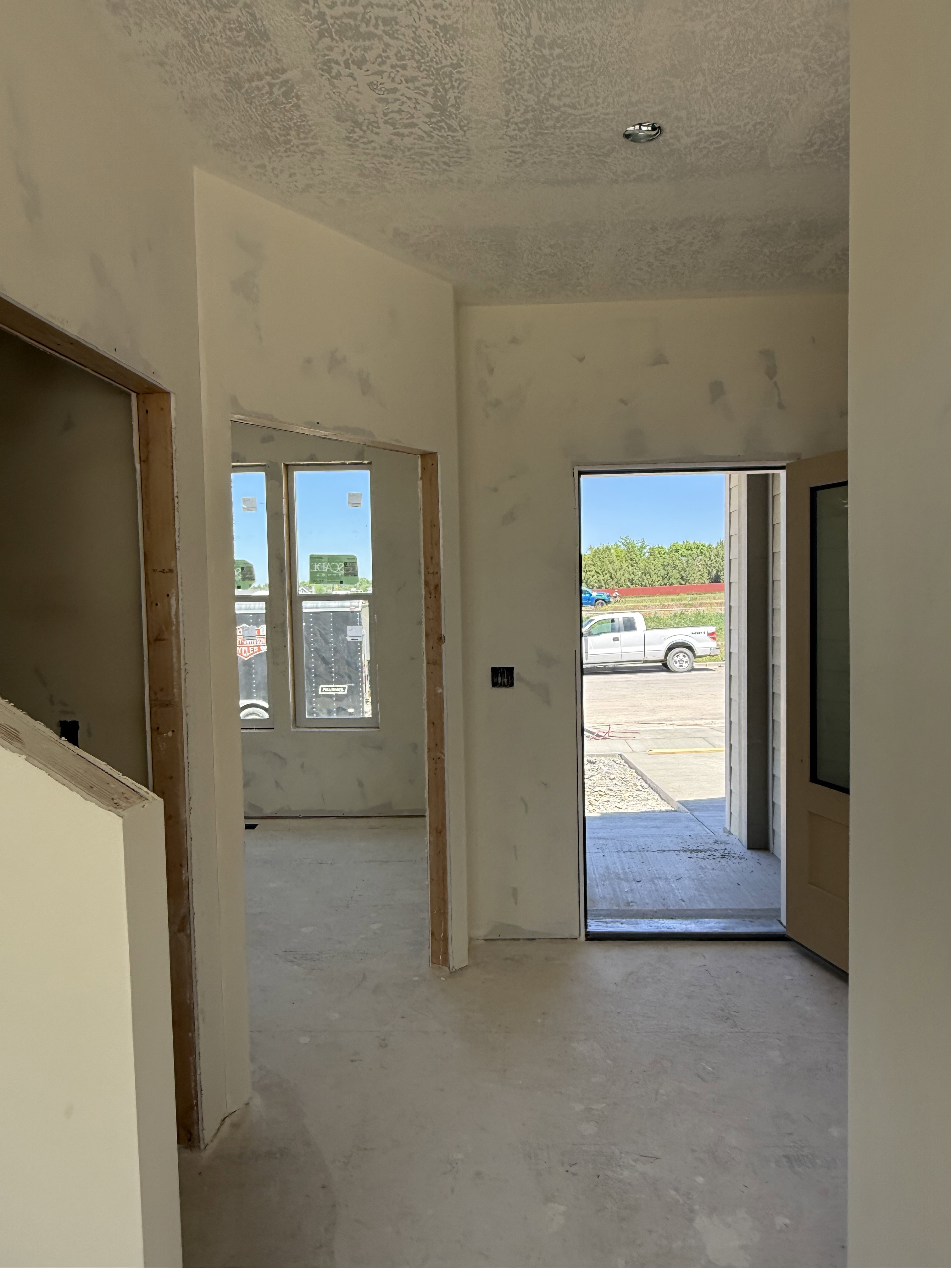 Interior entry hall featuring a solid core entry door, recessed lighting, and multiple window openings