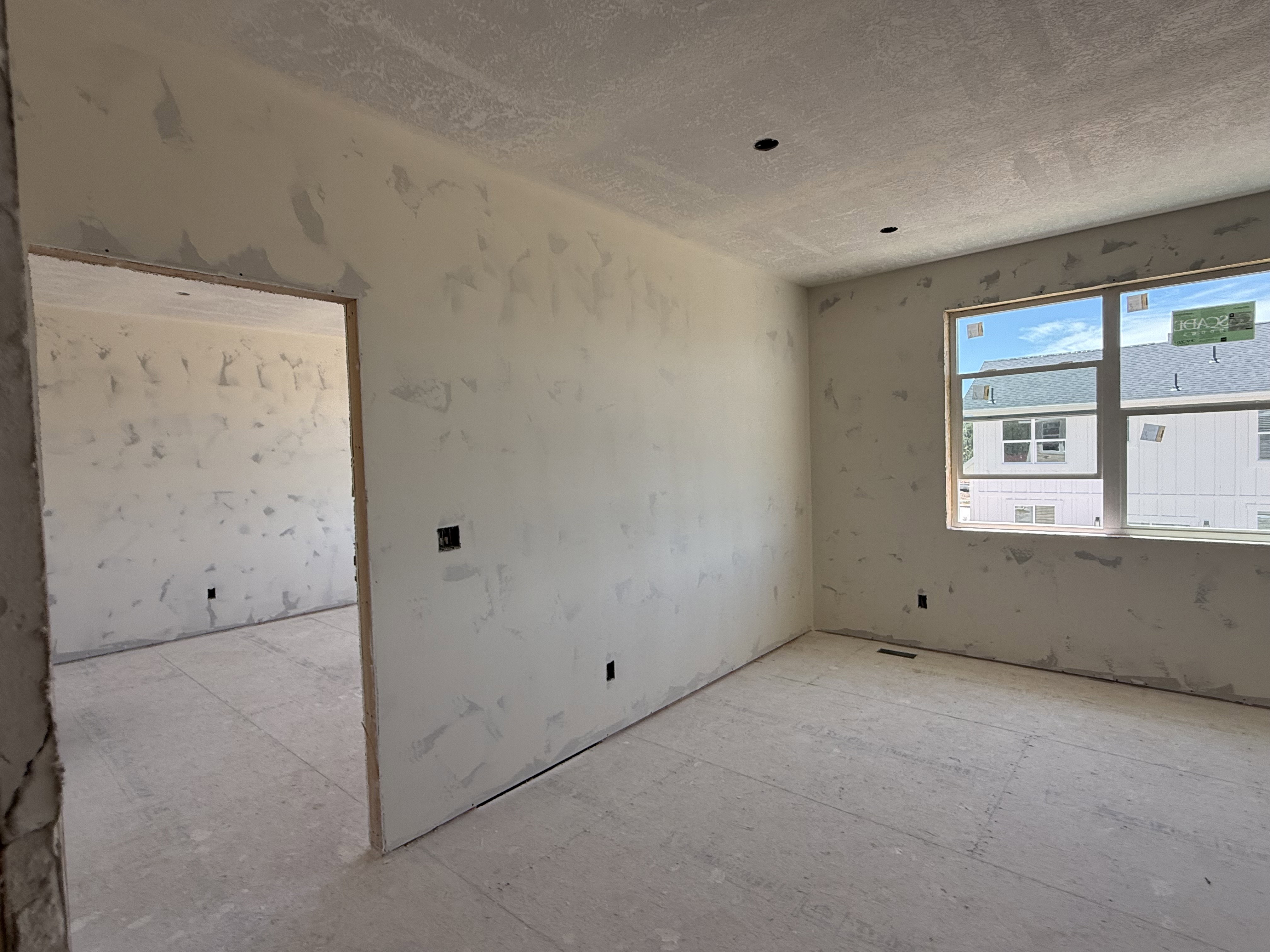 Unfinished interior space with drywall and a window