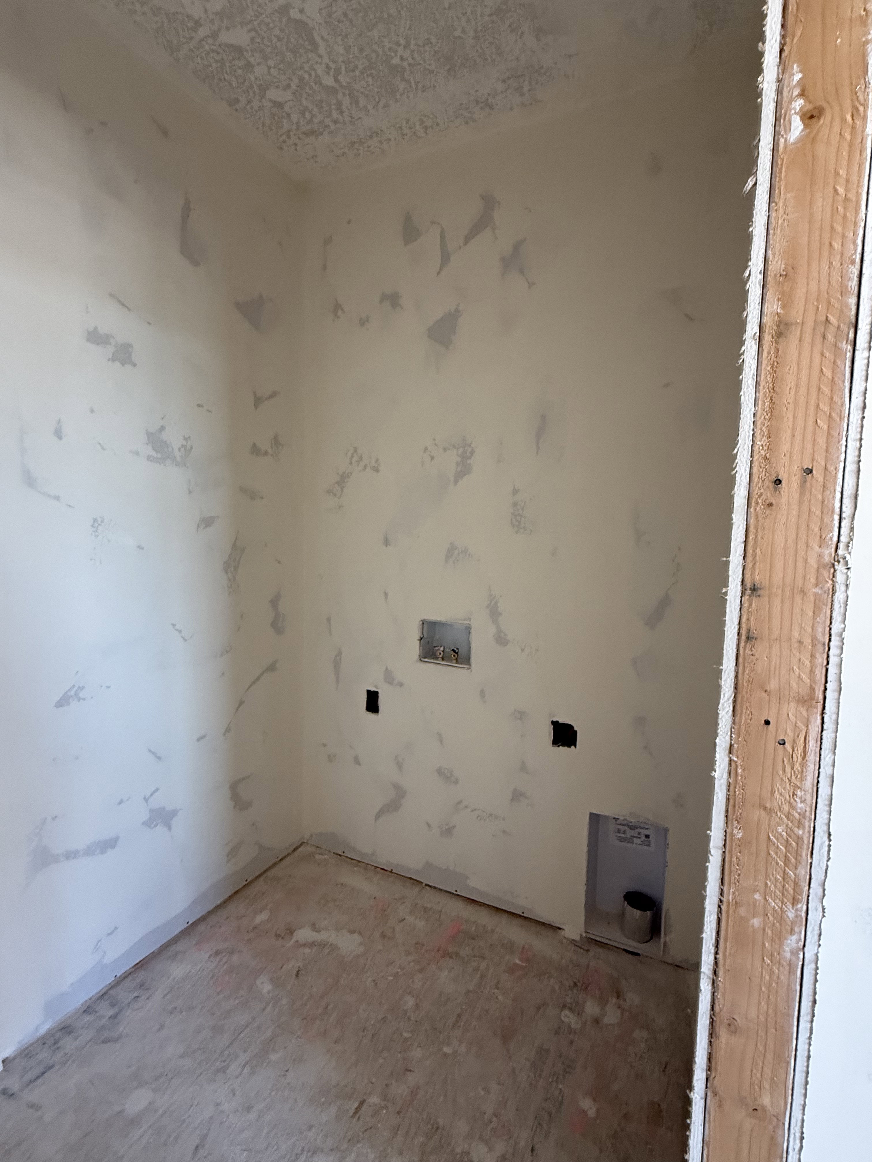 Utility space featuring roughed-in plumbing and electrical outlets, unfinished walls and ceiling, and exposed subfloor