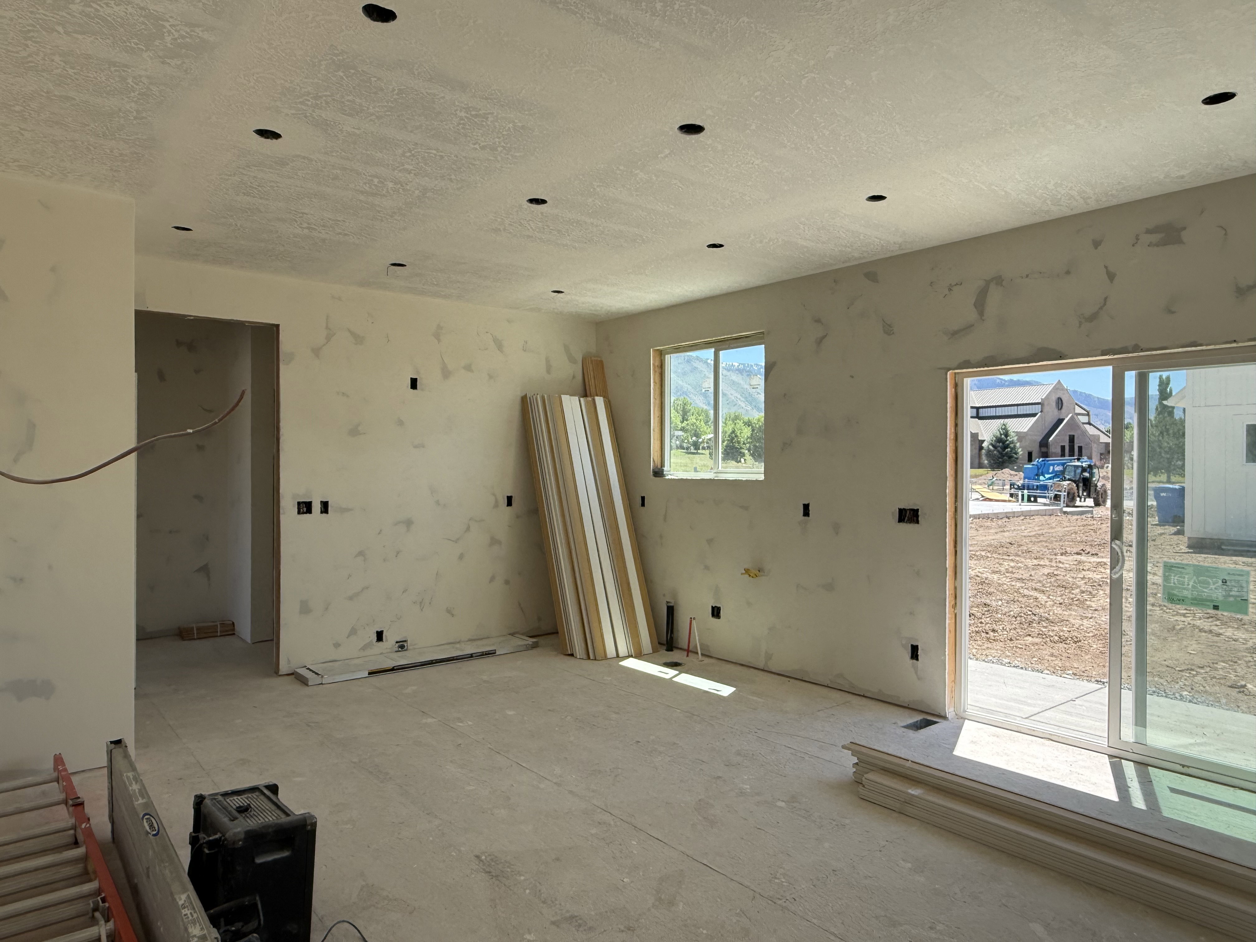 Spacious interior room under construction, featuring recessed ceiling lighting throughout