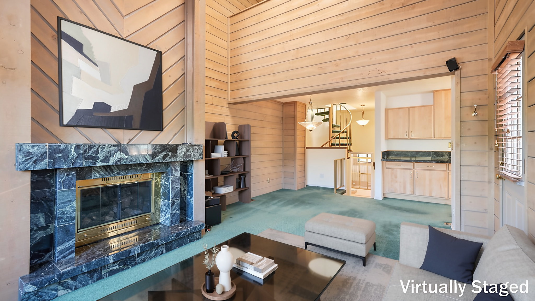 Living area featuring a stone-clad fireplace with a brass firebox, wood-paneled walls, and soft green carpeting