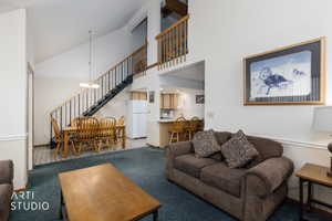 Vaulted ceiling living space with a dining area featuring wood-finish flooring