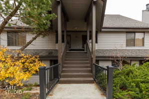 Multi-level exterior entrance featuring dark wood steps and railings