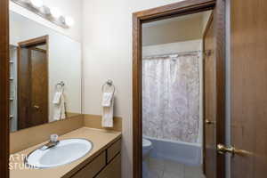 Bathroom vanity featuring a single basin sink and a mirror with overhead lighting