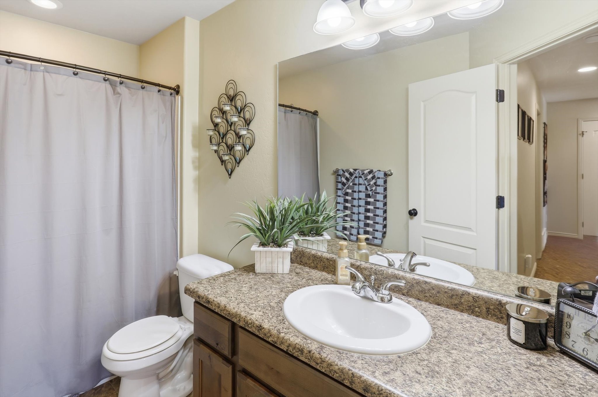 Bathroom featuring a vanity with a laminate countertop, integrated sink, and wood-finish cabinetry