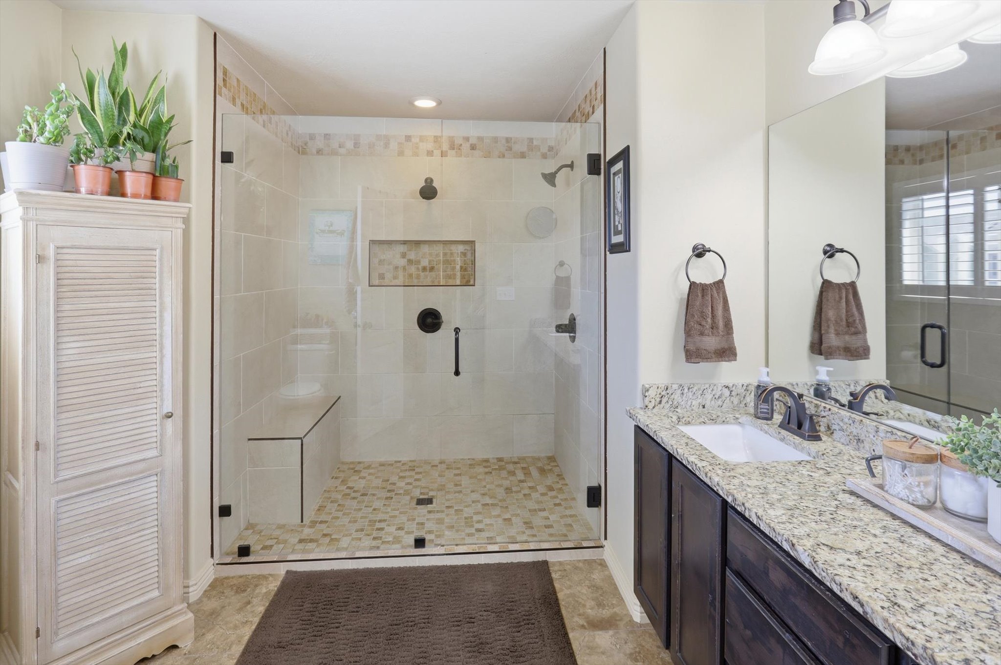 Walk-in shower with clear glass enclosure and integrated bench seating