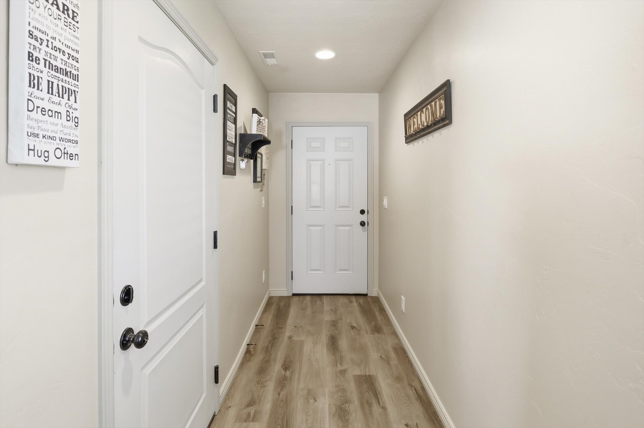 Hallway entry featuring wood-finish flooring, light-toned walls, and recessed lighting