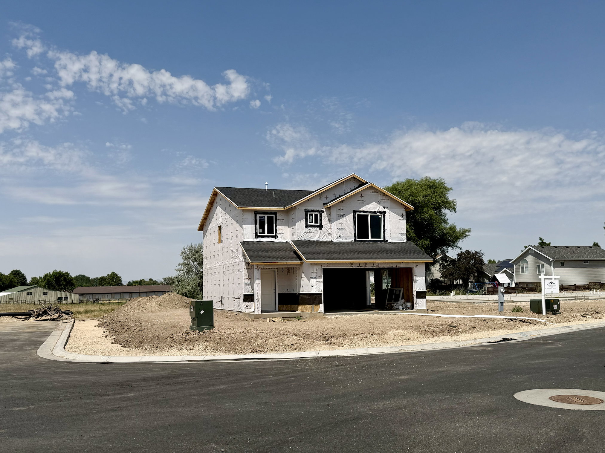 New construction residence featuring a two-story design, dark shingle roofing, and a two-car garage opening
