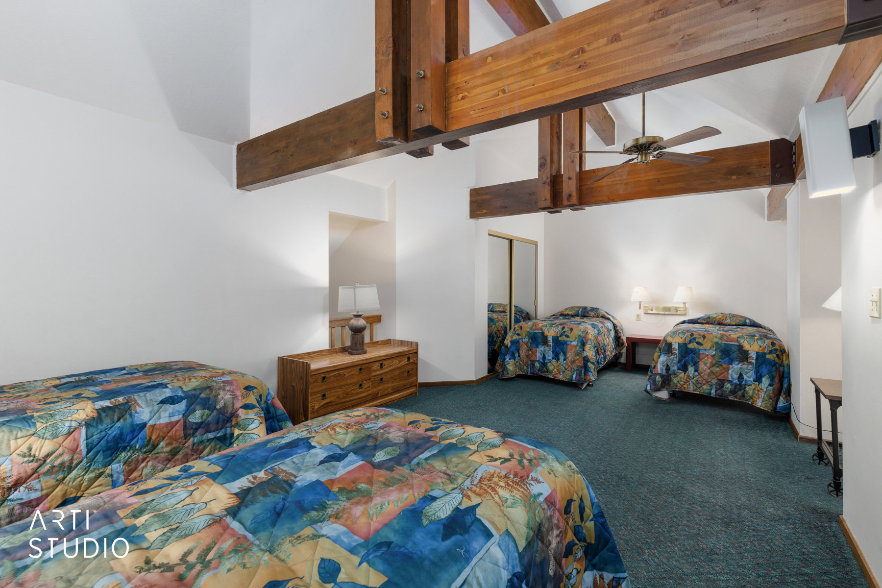 Vaulted ceiling featuring exposed wood beams and a ceiling fan