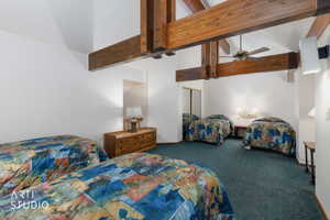 Vaulted ceiling featuring exposed wood beams and a ceiling fan