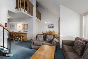 Vaulted ceilings enhance the main living area featuring plush carpeting