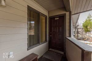 Entryway featuring a paneled door, horizontal siding, and an overhead lighting fixture
