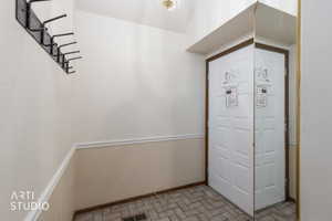 Entryway featuring panel door with decorative trim, full-height mirror, and ceramic tile flooring