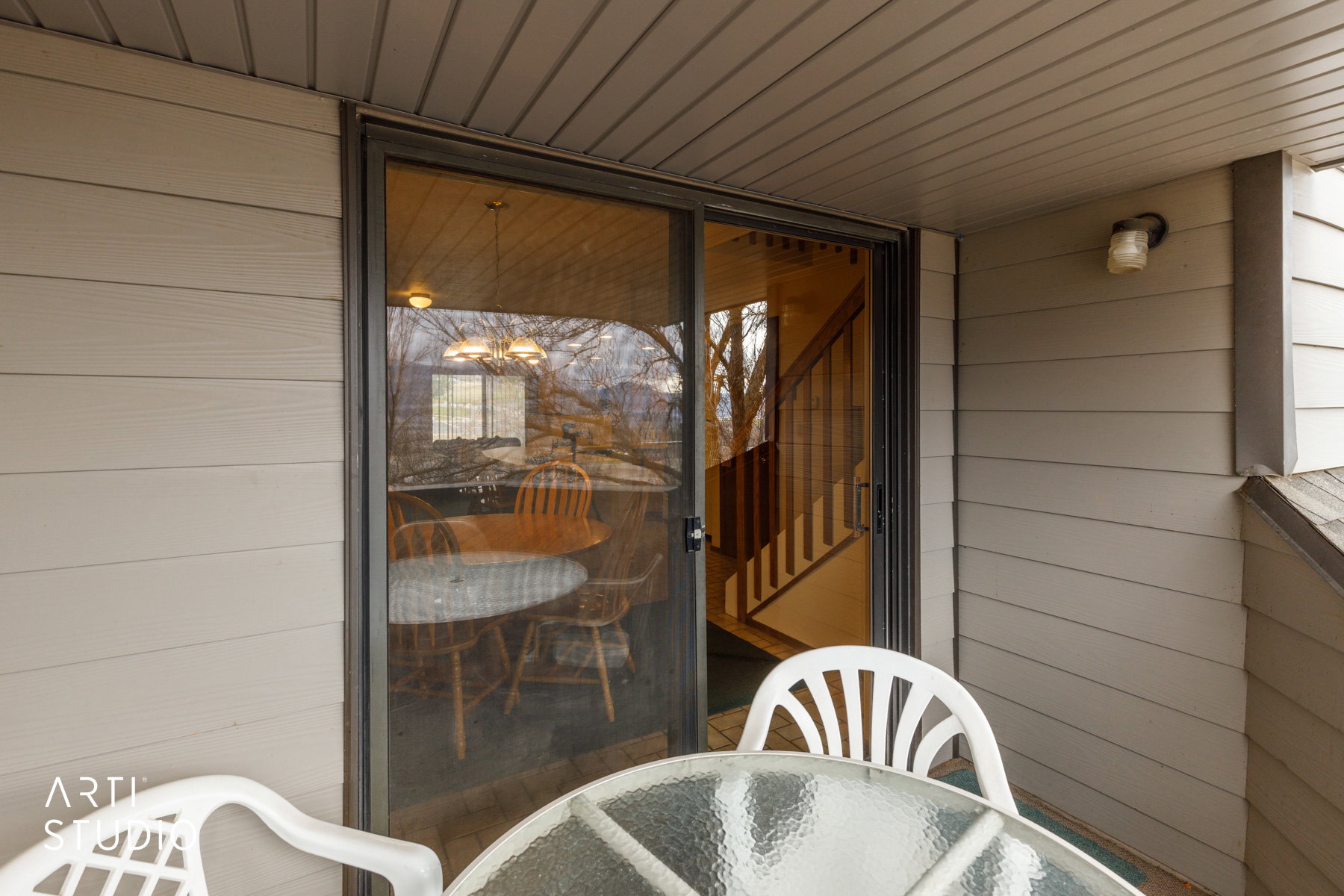 Outdoor patio area featuring horizontal siding and a sliding glass door