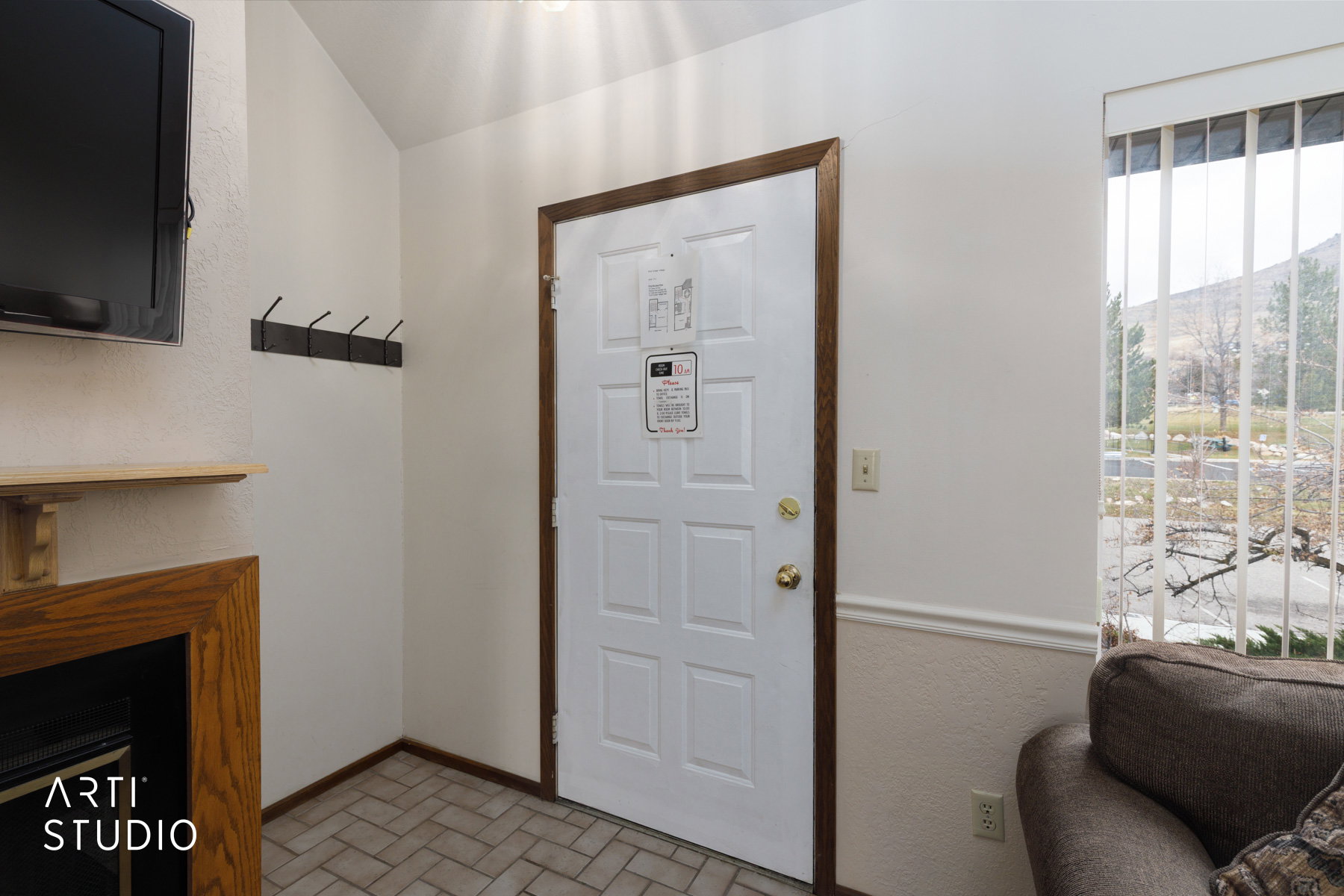 Entryway featuring a paneled door with wood-finish trim, herringbone tile flooring, and a window with vertical blinds