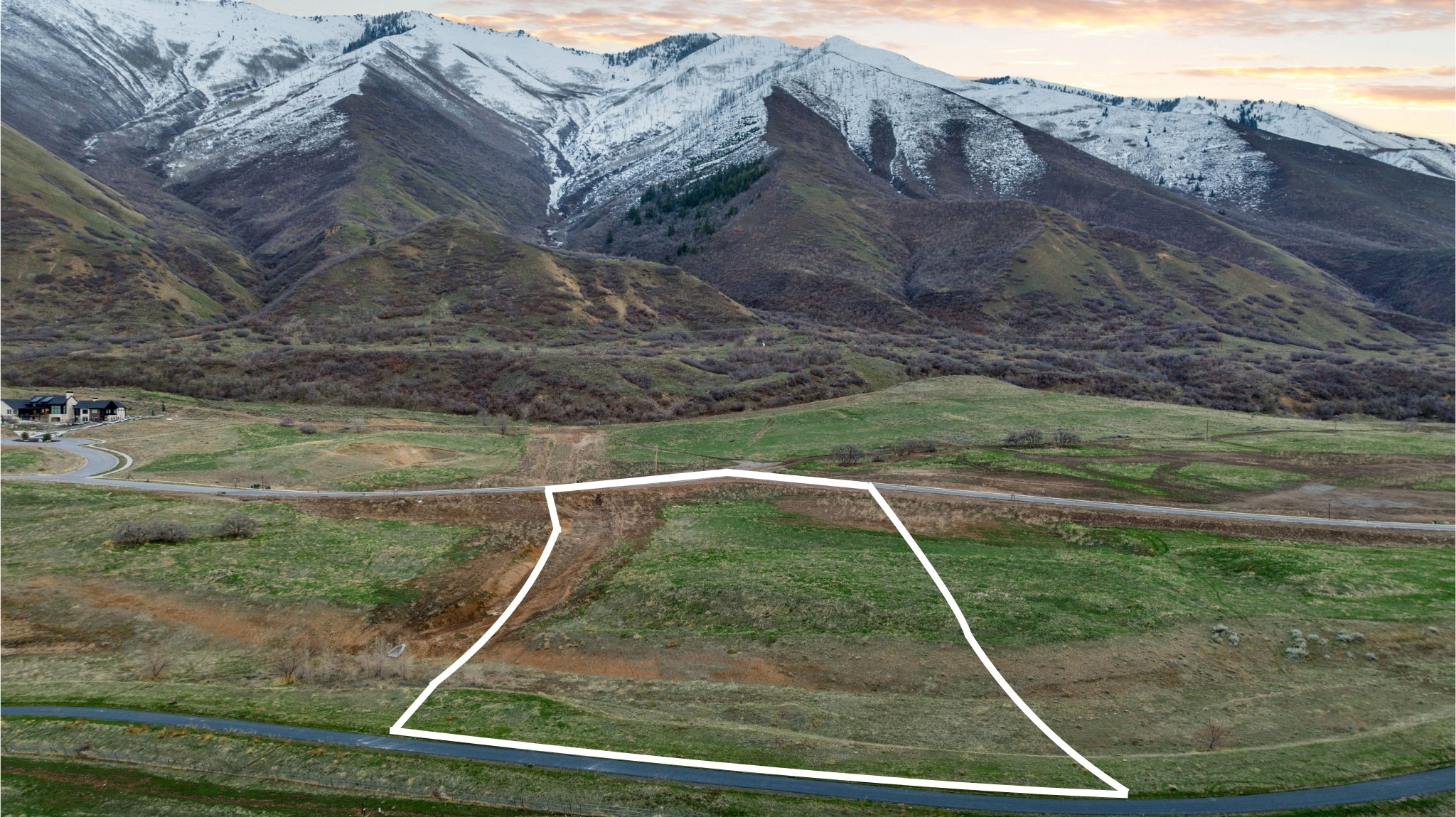 Expansive land parcel featuring natural terrain and distant snow-capped mountains