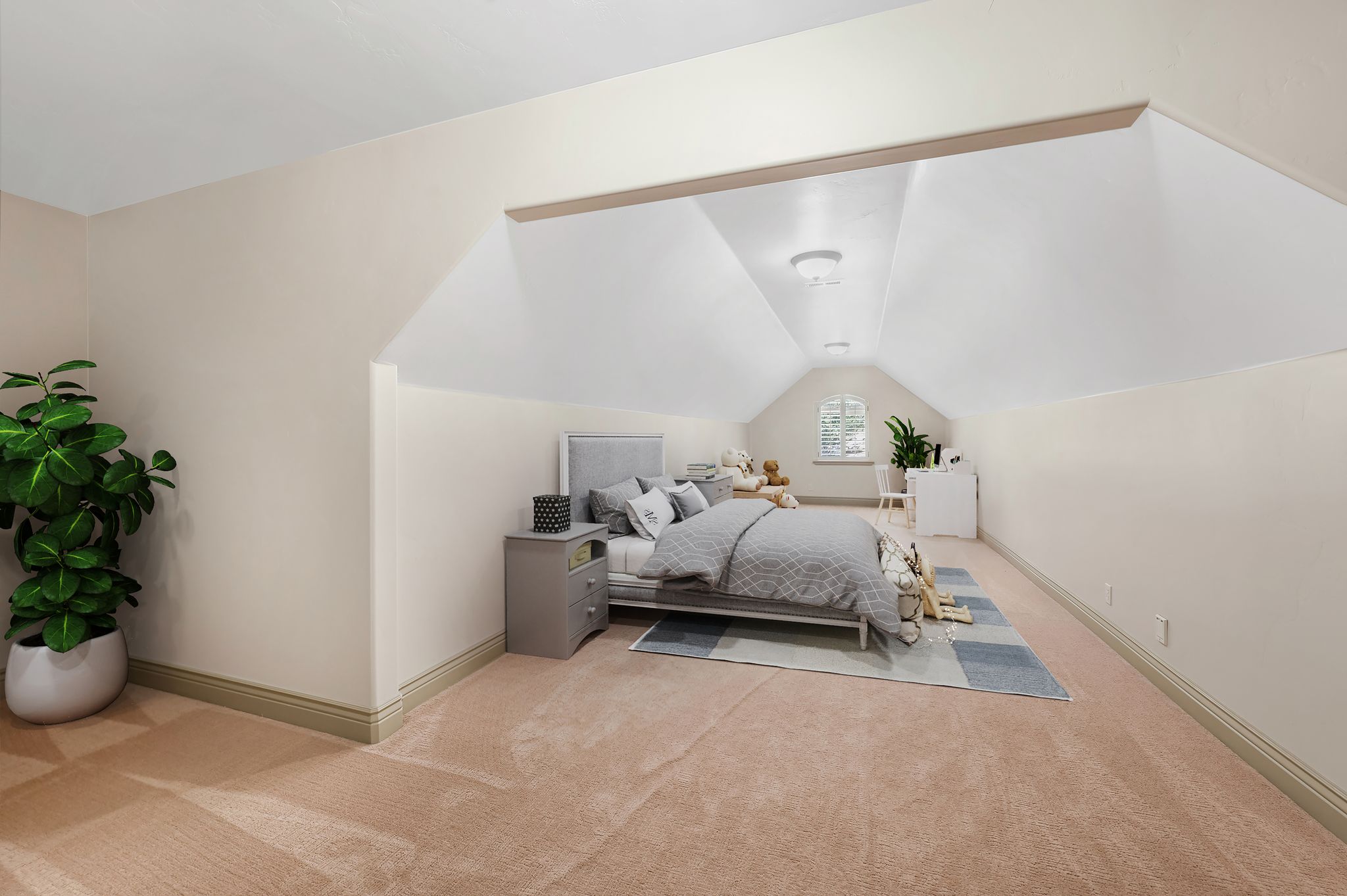 Spacious attic room featuring sloped ceilings, plush carpeting, and a built-in arched window