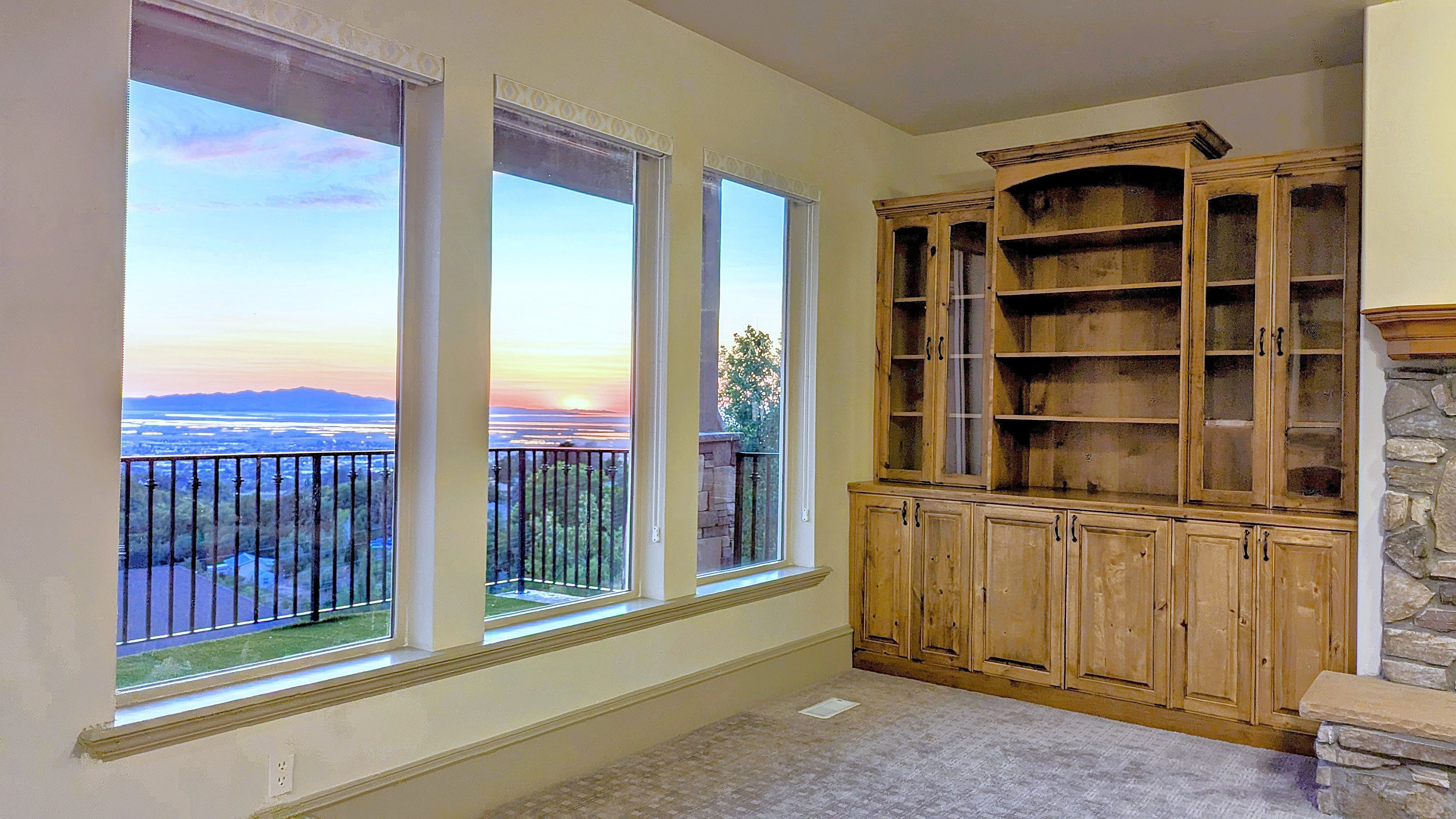Expansive windows framing a distant body of water and mountain range