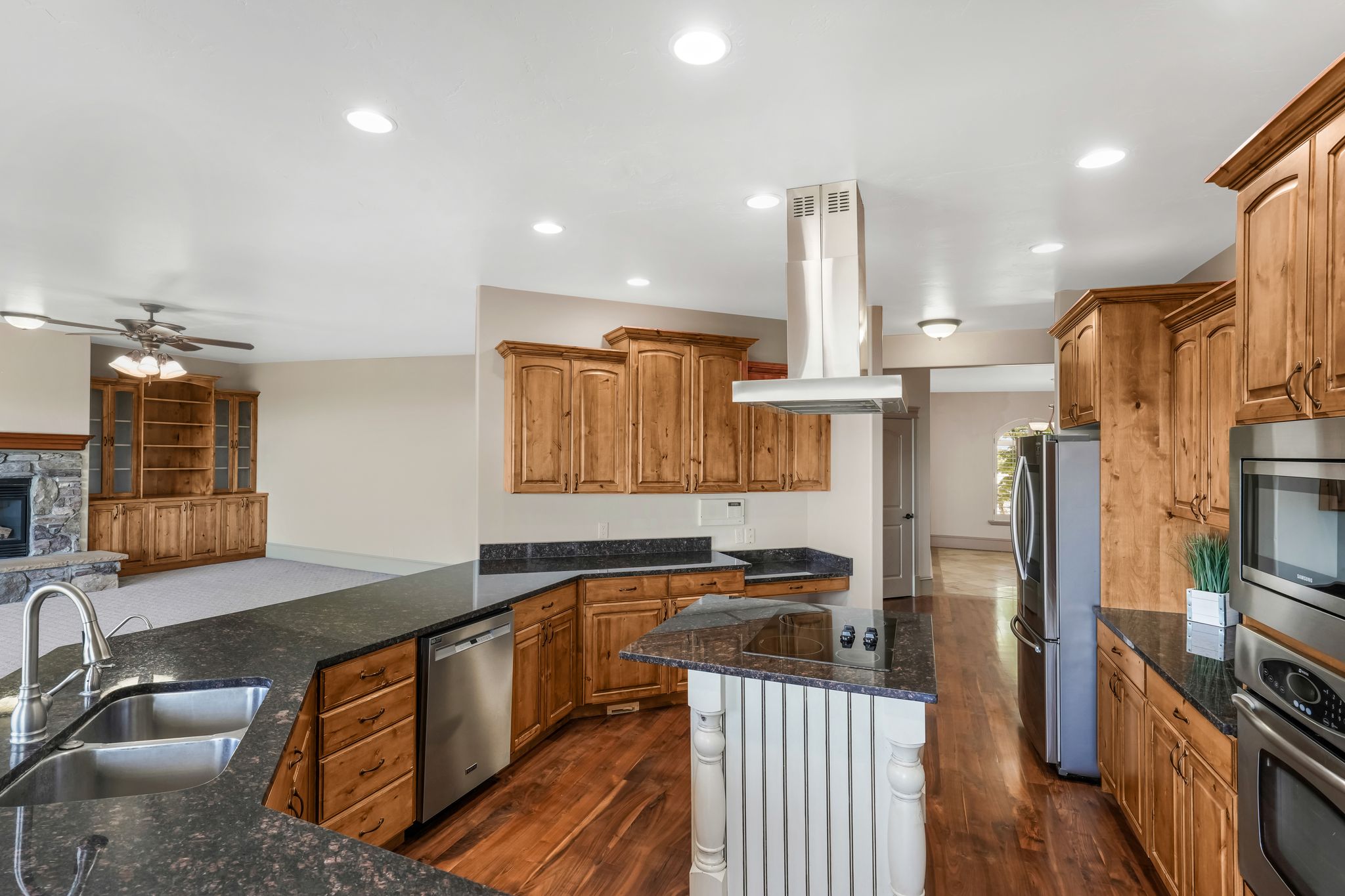 Kitchen featuring wood-finish flooring, dark granite countertops, and stainless steel appliances