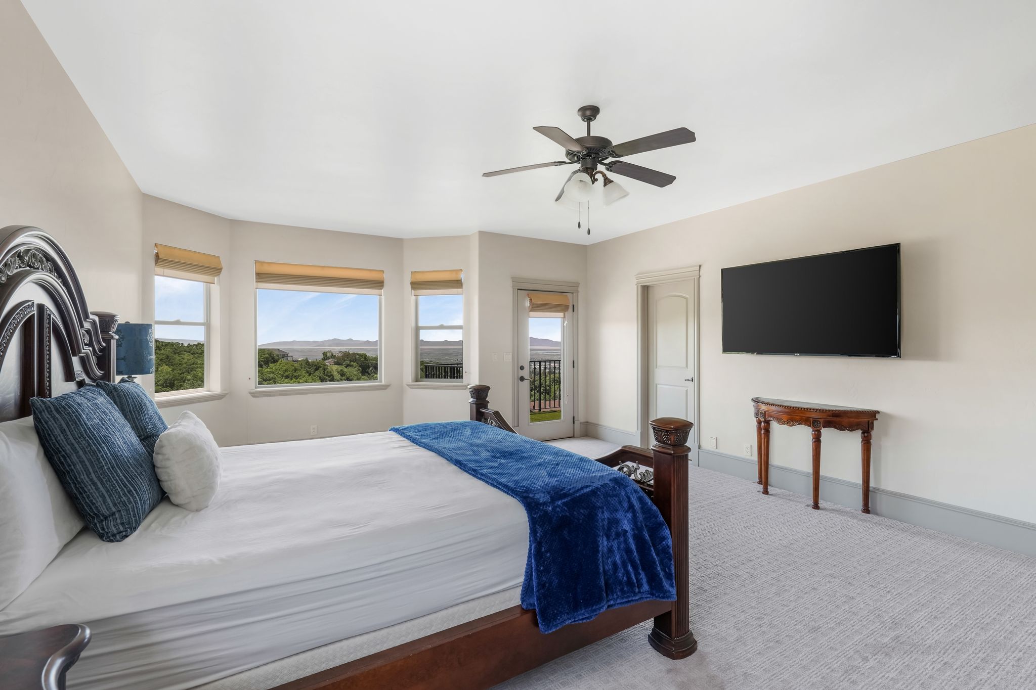 Spacious room featuring multiple windows, a ceiling fan, and wall-to-wall carpeting