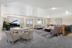 Spacious multi-zone room featuring recessed lighting, a built-in wooden baluster with metal spindles, multiple windows, and exterior French doors