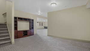 Spacious lower-level area featuring neutral-toned walls, patterned carpeting, and recessed lighting fixtures