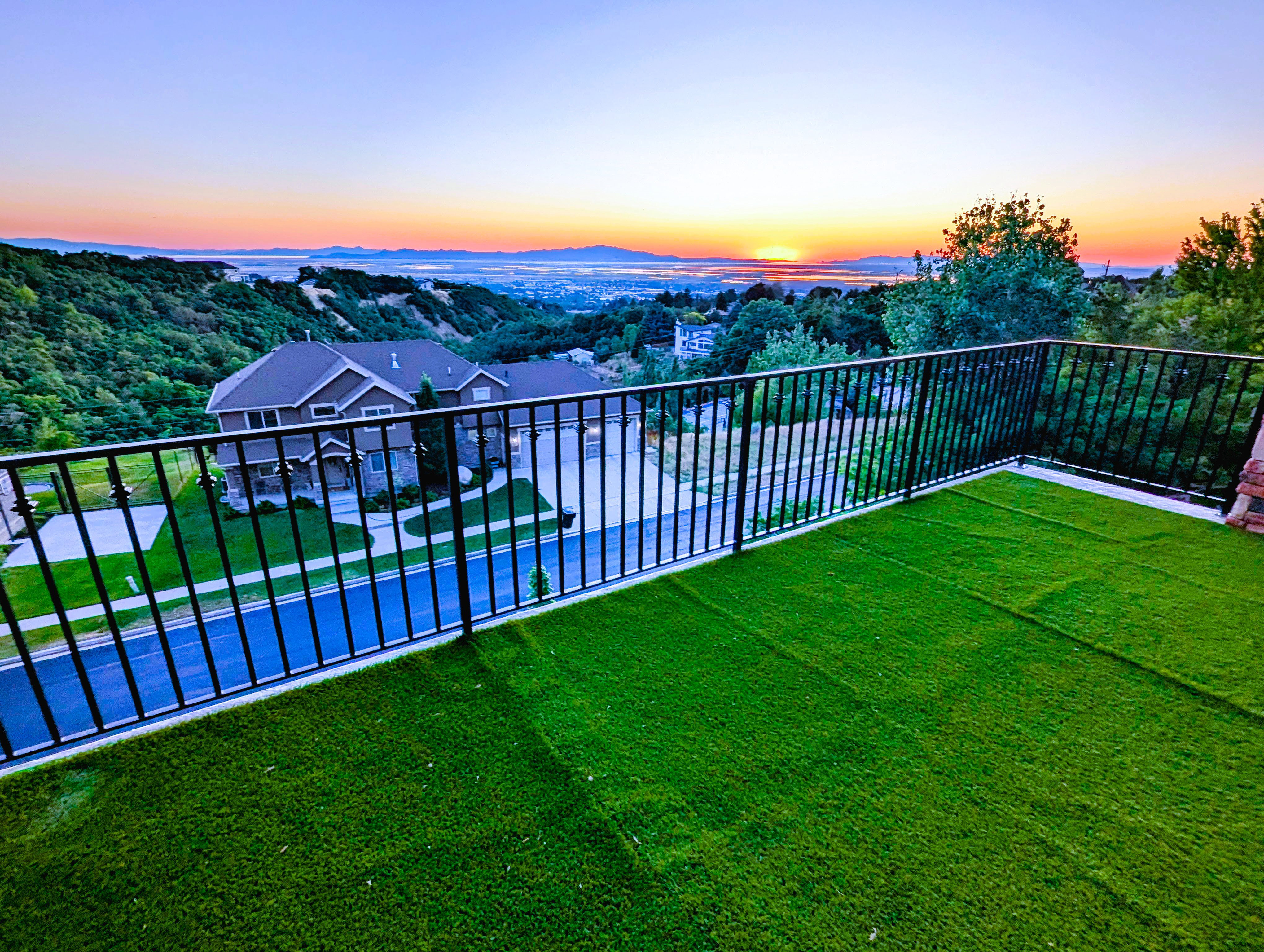 Upper-level balcony featuring artificial turf flooring and black metal railings