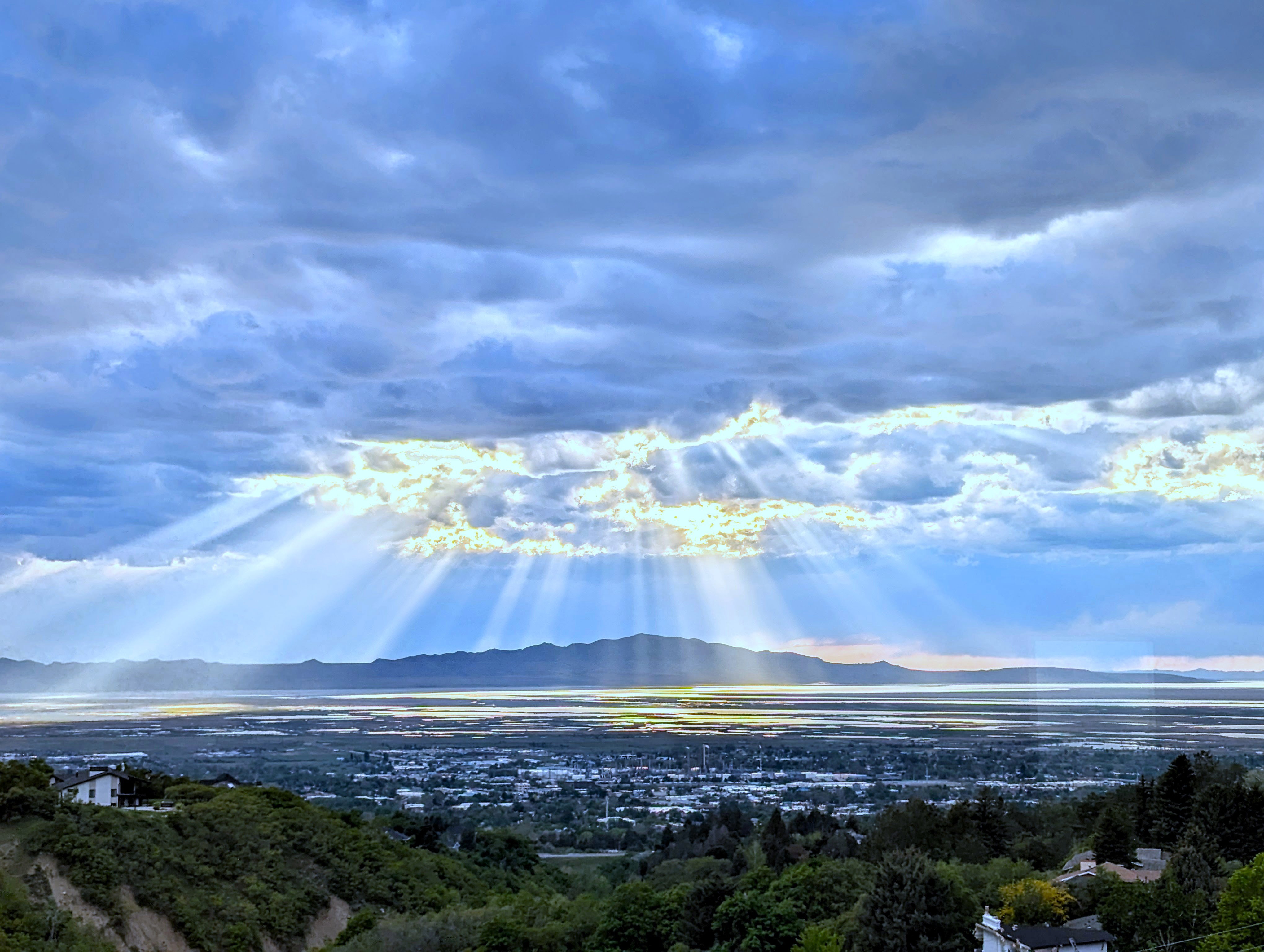 Expansive mountain and lake scenery frames a distant city