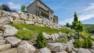 Terraced landscaping featuring large natural rock retaining walls and varied plantings
