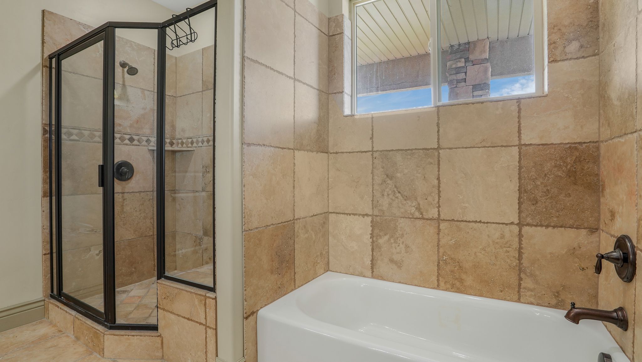 Bathroom featuring a walk-in shower with a glass enclosure, an integrated shower niche, and bronze fixtures