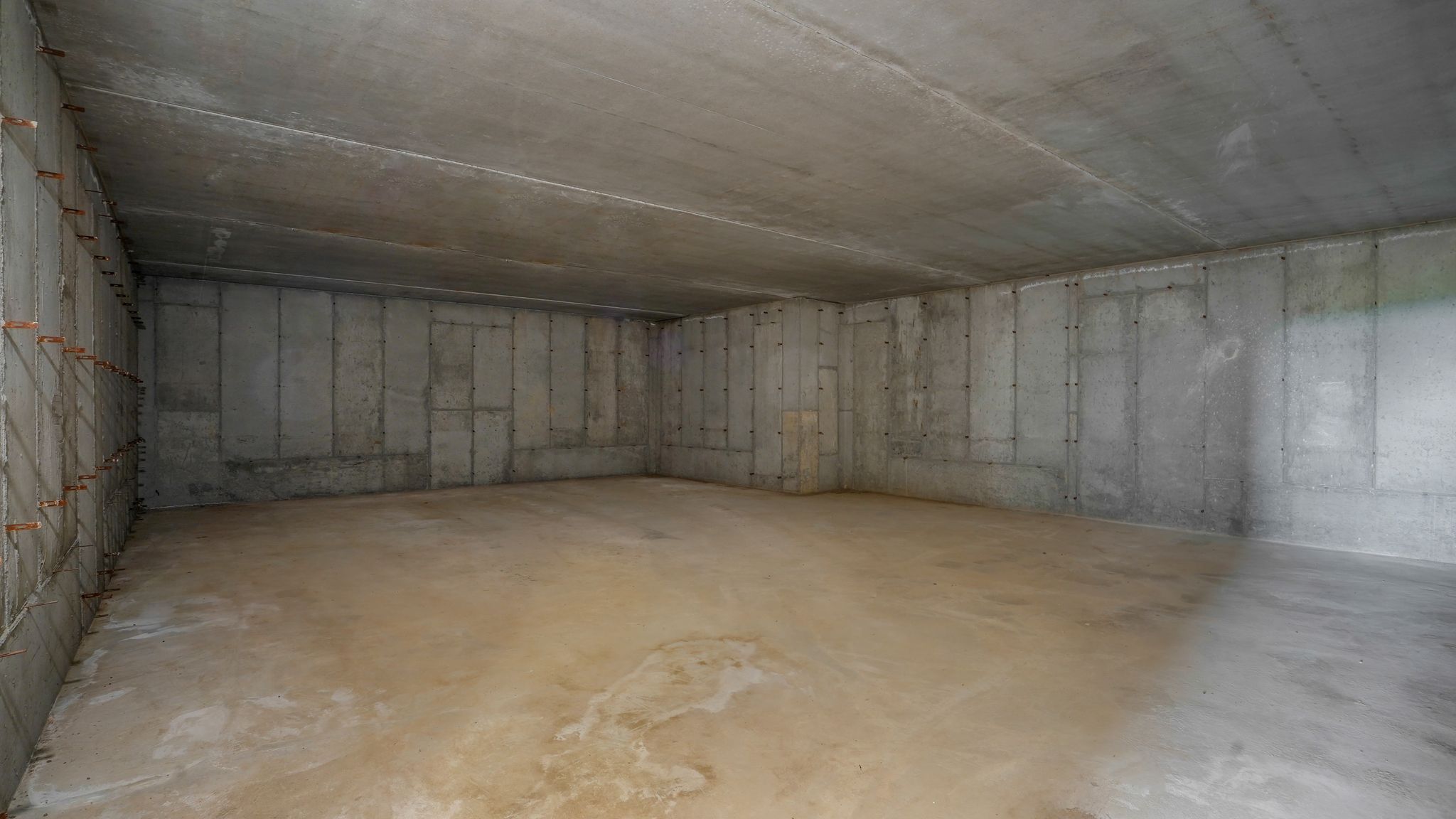 Unfinished basement featuring concrete walls and flooring