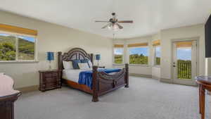 Spacious room featuring light-colored walls, patterned carpeting, and a ceiling fan