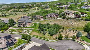 Expansive residential setting featuring multiple homes on terraced lots, surrounded by natural hillside landscaping