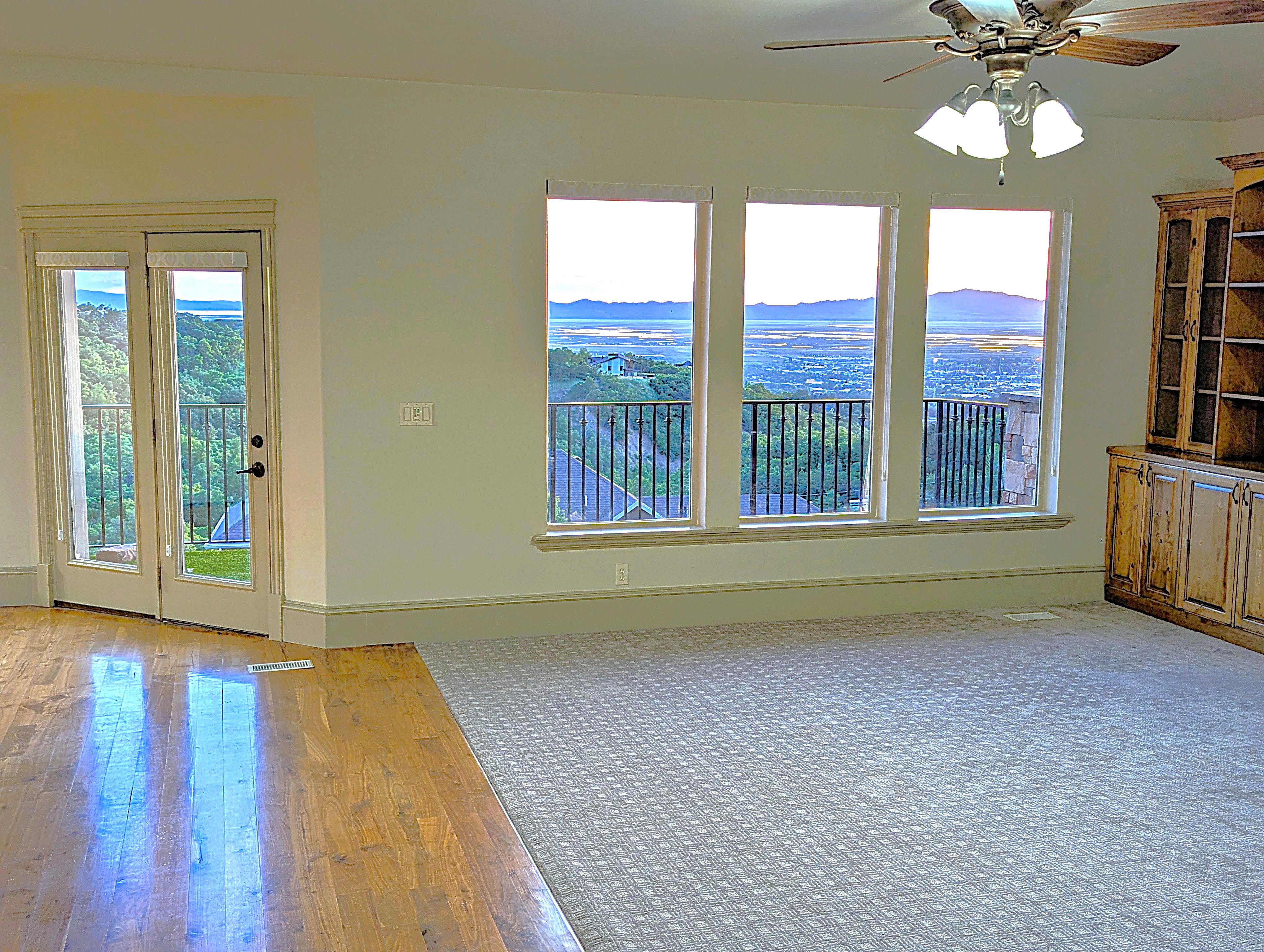Expansive room featuring multiple windows and a glass-paneled door, offering panoramic scenery