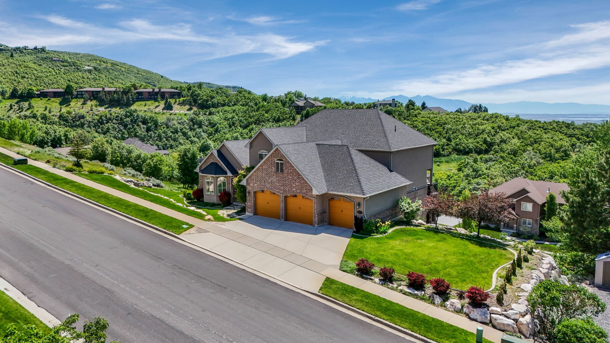 Expansive residential property featuring a multi-level design, brick and stucco exterior, and a three-car garage