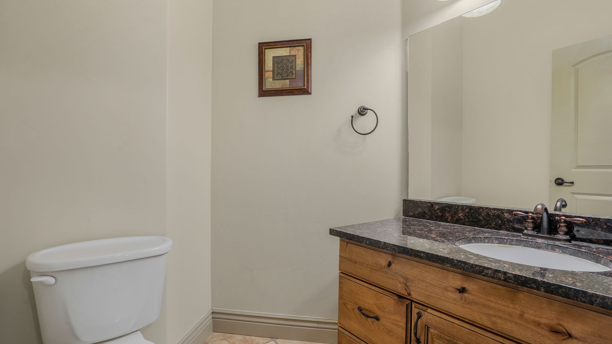 Bathroom vanity featuring a dark stone countertop with an undermount sink and oil-rubbed bronze faucet