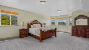 Spacious room featuring patterned gray carpeting, multiple windows, and light beige walls