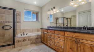 Dual vanity with wood-finish cabinetry and dark stone countertops
