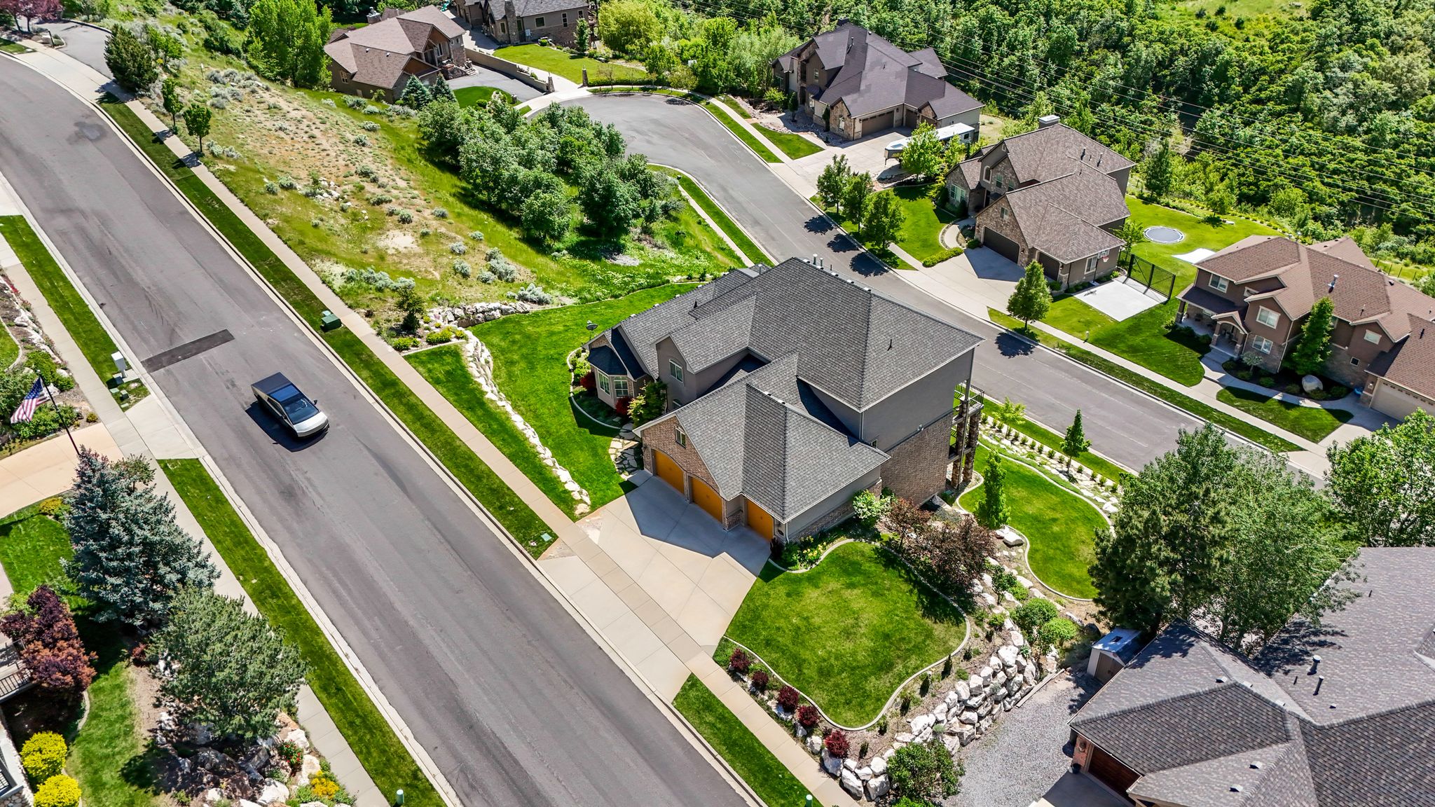 Residential property featuring a multi-level roofline, attached garages, and a paved driveway