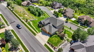 Residential property featuring a multi-level roofline, attached garages, and a paved driveway