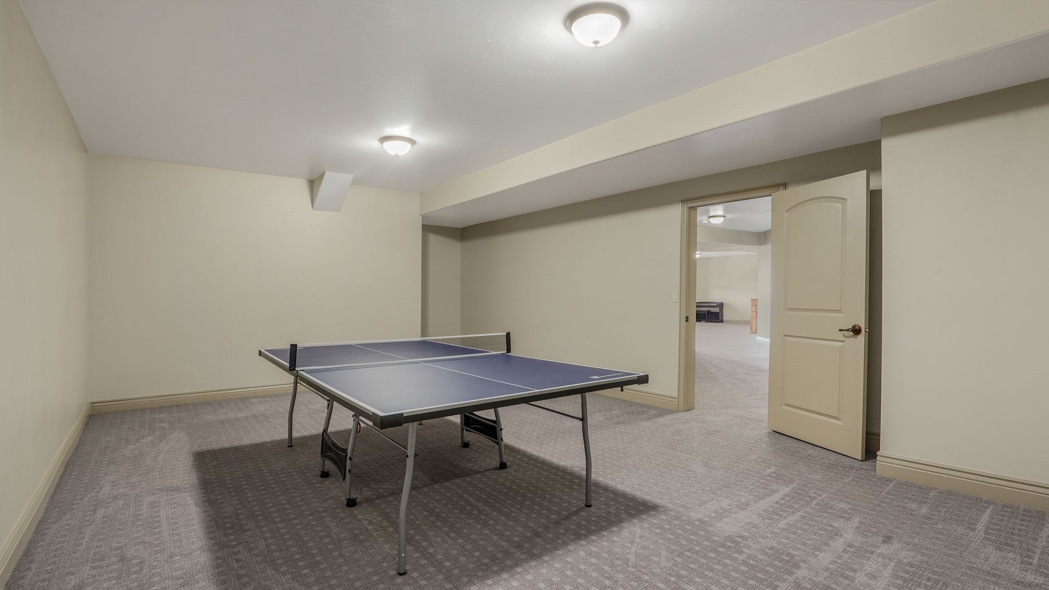 Spacious room featuring patterned carpeting and neutral wall tones