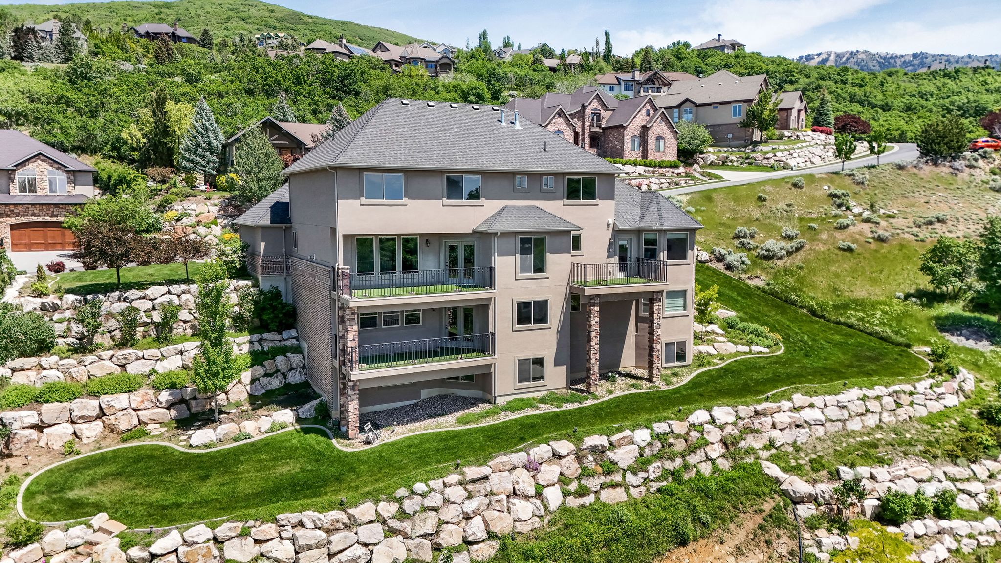 Terraced hillside property featuring extensive rock retaining walls and manicured green spaces