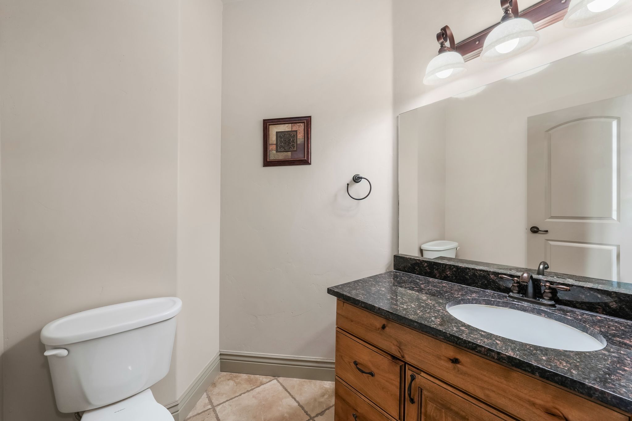 Bathroom featuring a vanity with a dark countertop, an oval undermount sink, and a dark bronze faucet