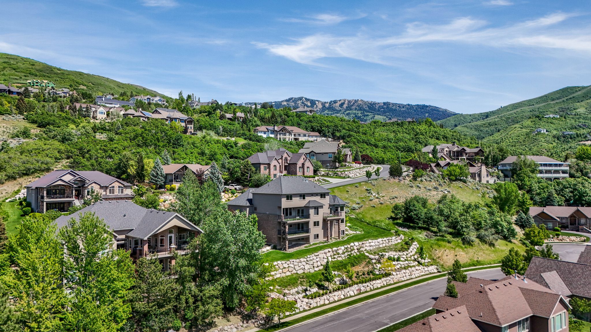 Lush green hillside setting with a paved roadway and extensive rock retaining walls