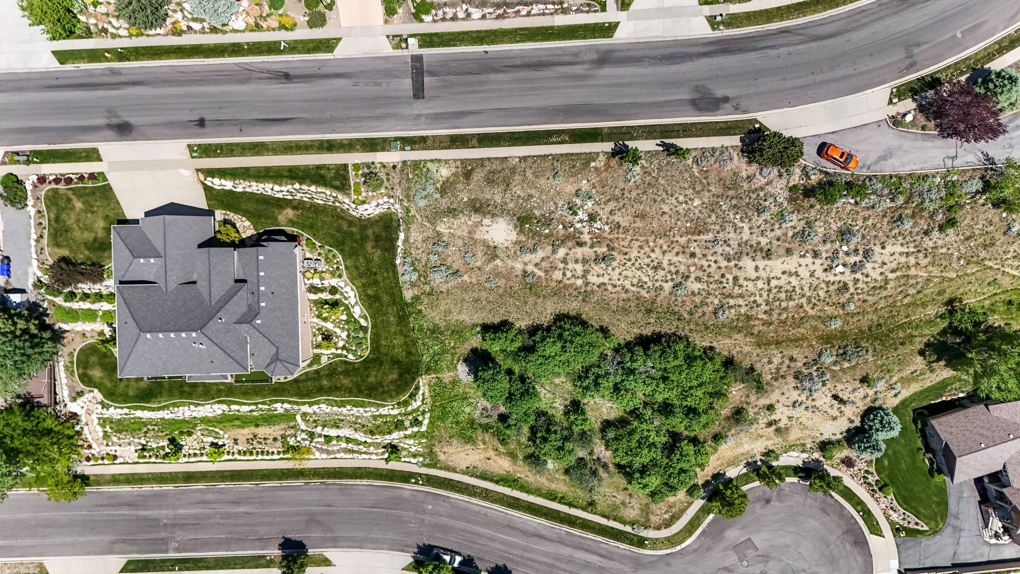 Expansive residential lot featuring a curved street frontage, established landscaping, and a substantial building footprint